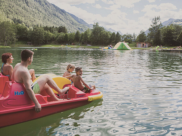 Familie in einem Tretboot im Badesee Ried im Sommer